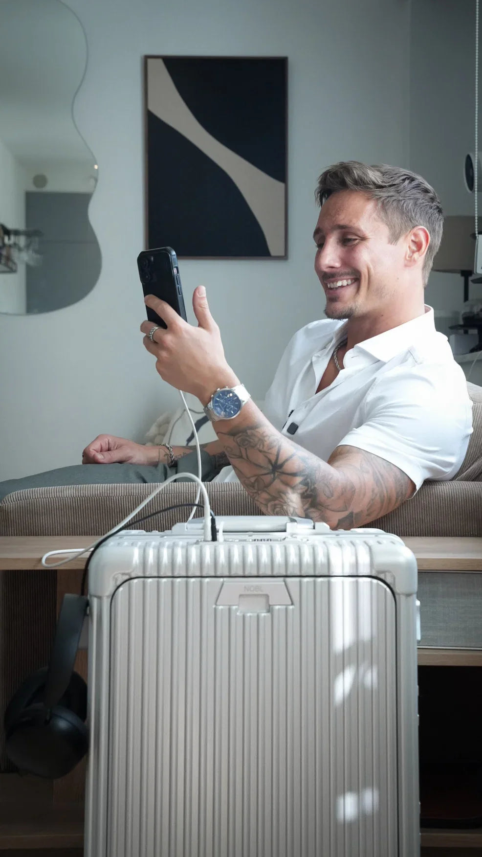 Smiling traveler with silver luggage