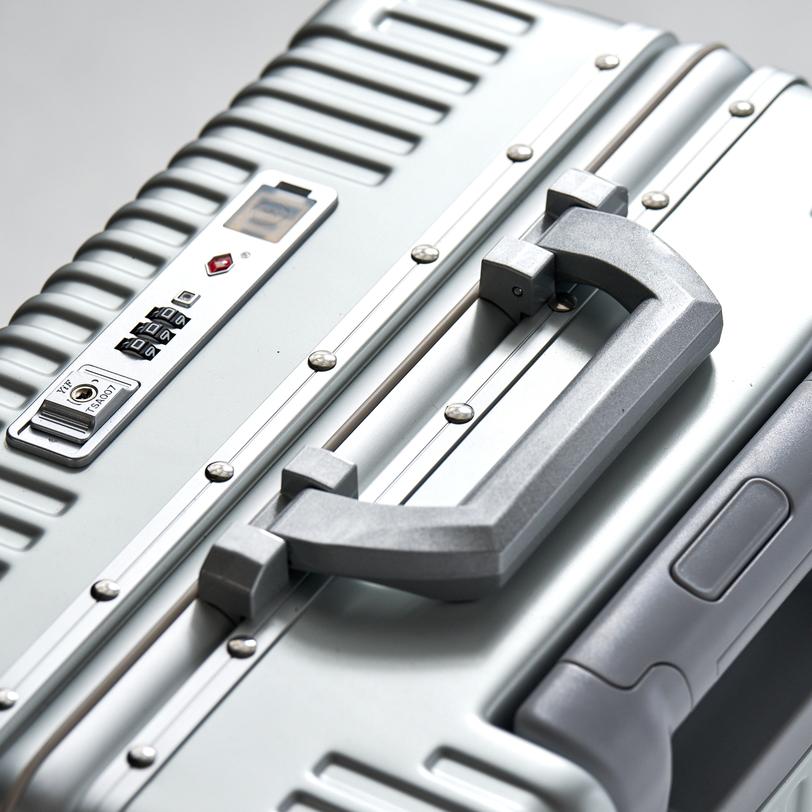 Red NOBL carry-on showing two TSA locks on the rigid aluminum frame